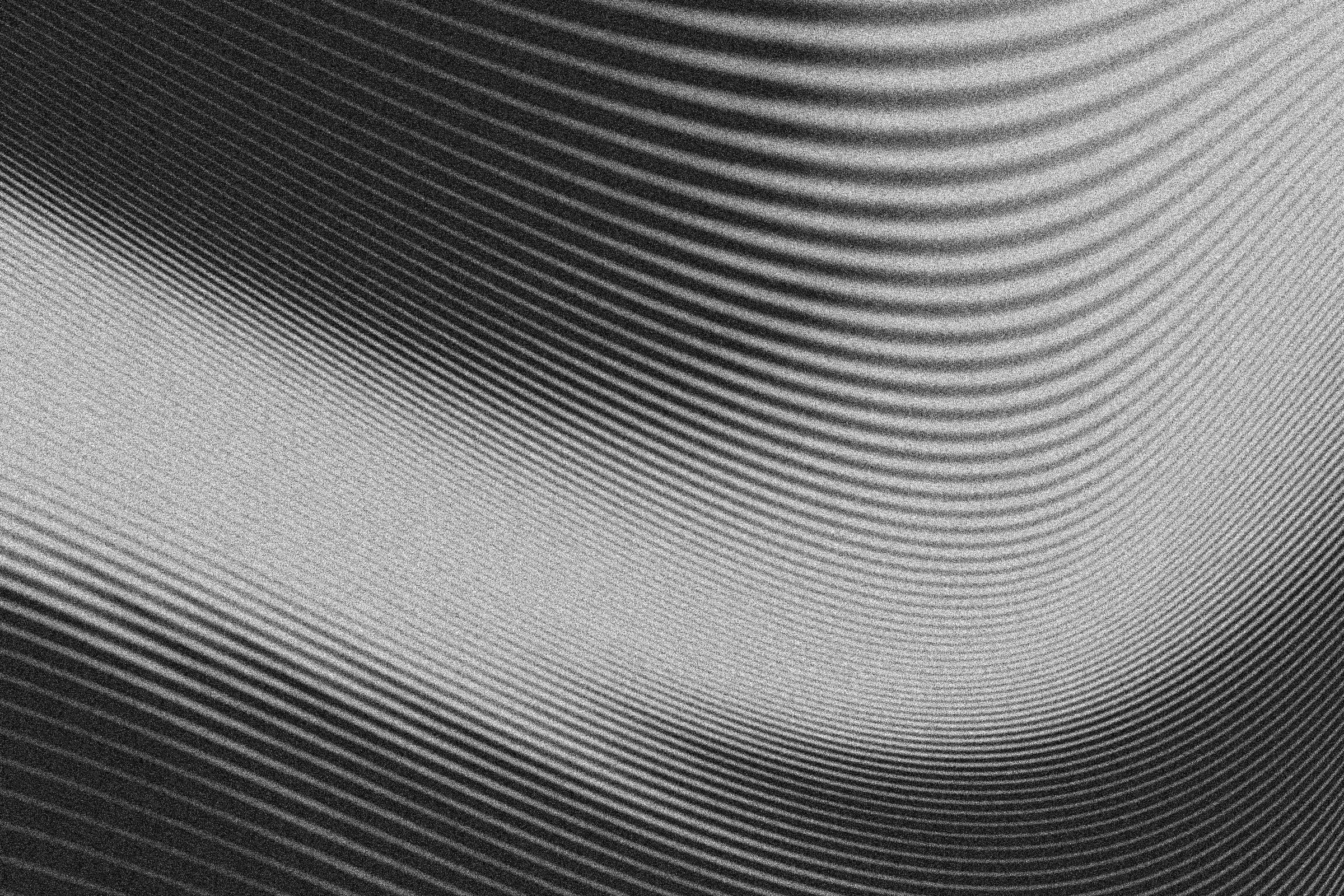 Black and gray curved lines forming layered waves on a pale grainy background.